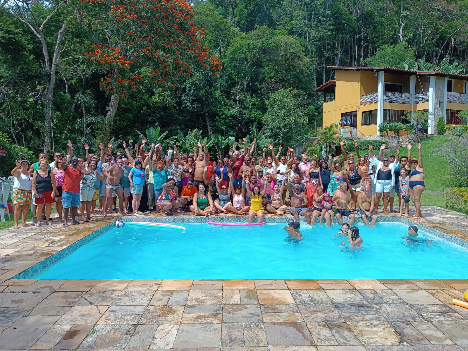 Grande grupo familiar reunido na piscina do sítio